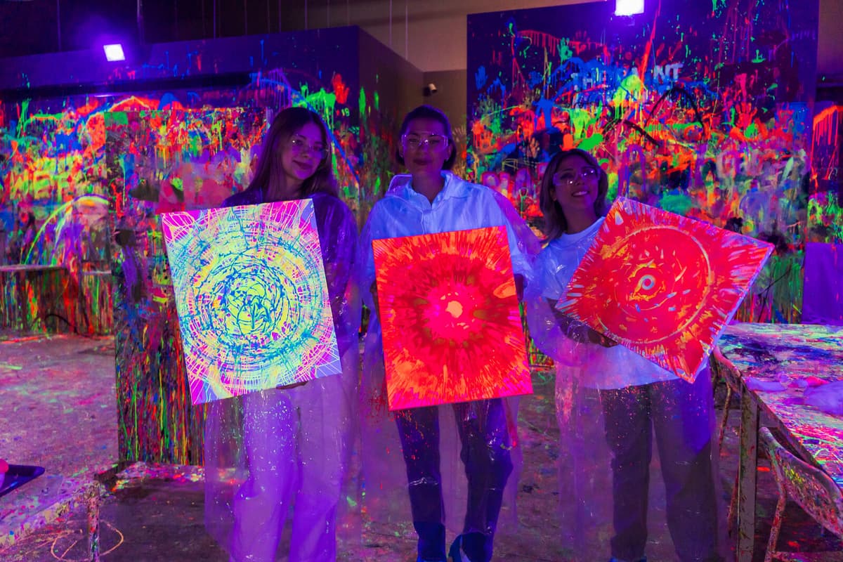 Friends holding their finished neon artworks
